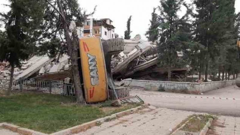 Hasarlı bina yıkımı esnasında iş makinesi devrildi