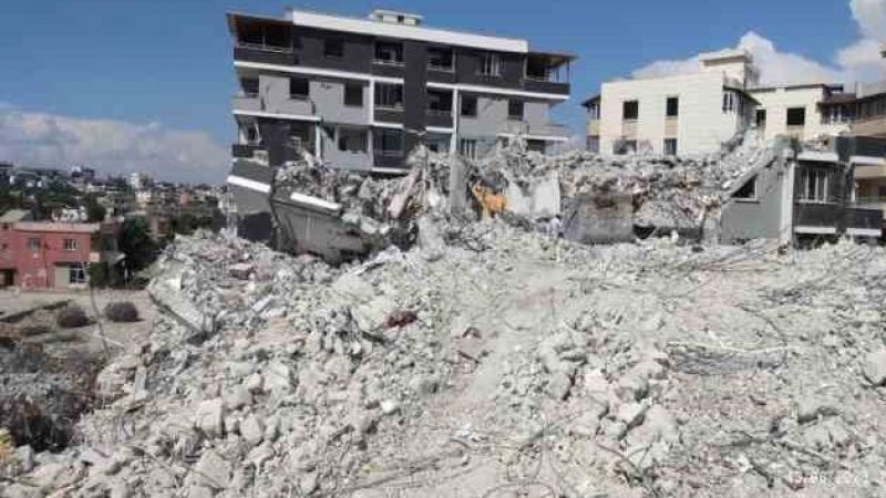 Ağır hasarlı binayı yıkan kepçe operatörü enkaz altında kaldı