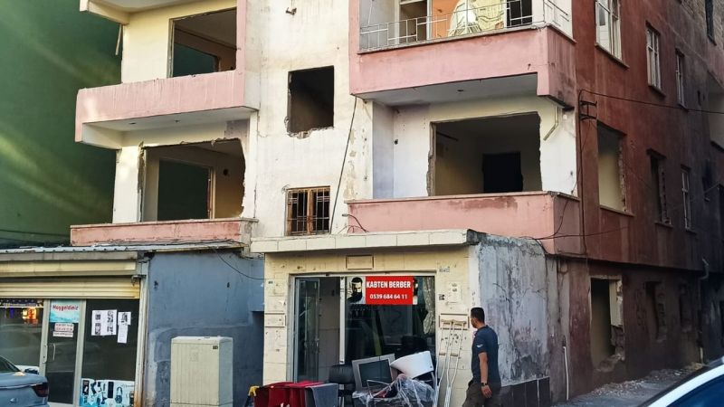 Ağır hasarlı binanın altında kepenk açtı