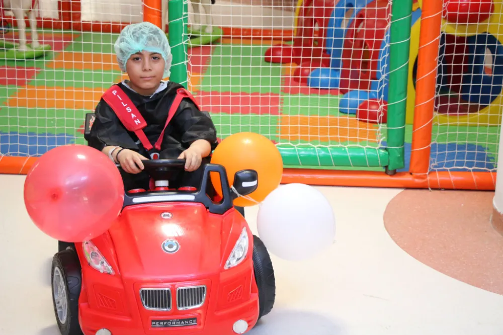 Çocuklar gülerek bindikleri akülü arabayla ameliyata giriyor